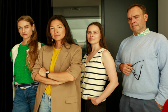 Group of Four People Standing in an Office Setting During the Day