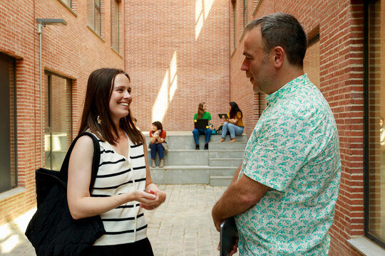 Friends Talk in a Modern Building Courtyard in the City