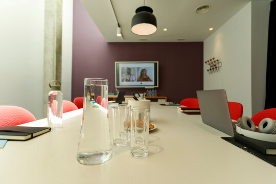 Meeting Room Setup With Water, Glasses, and Electronics