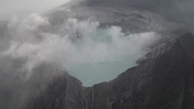 Aerial View of Kawah Ijen Volcanic Crater Acid Lake with Rising Steam and Fog in East Java Indonesia