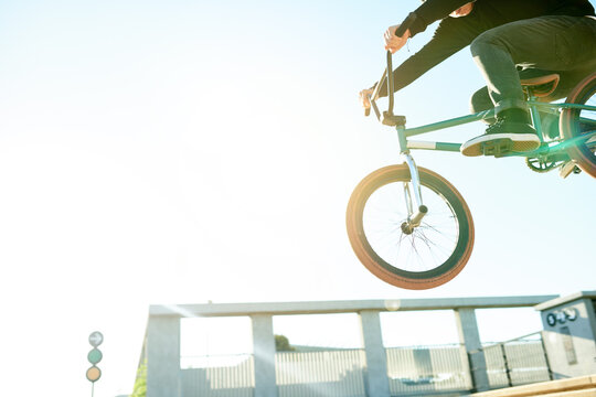 Bike, air and person with jump in city with space, trick or stunt for extreme sports outdoor. Skill, action and below athlete on bicycle for fitness, urban cyclist challenge or rider with talent