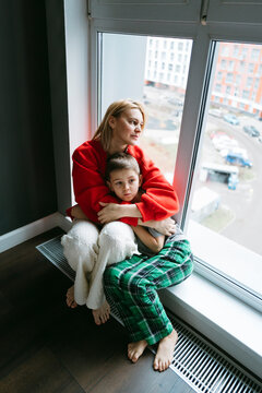 Sitting by the Window, Mother and Child Share a Quiet Moment