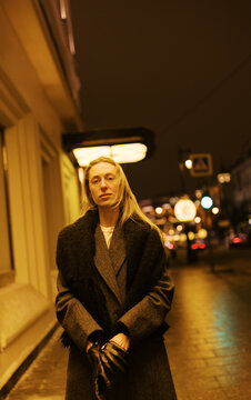 Woman Standing on Street at Night in City