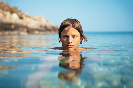 portrait of a teenage boy relaxing in calm mediterranean water