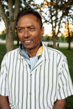 Candid portrait of mature man in park with thoughtful expression