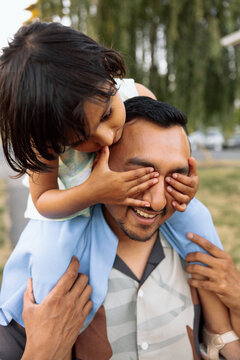 Candid father and daughter piggyback play showing real family joy