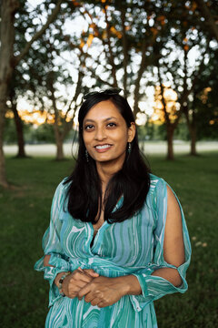 Candid outdoor portrait of a smiling woman in green dress