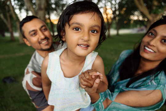 Candid family moment with smiling child and parents in park