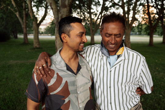 Father and adult son sharing a candid moment in a park