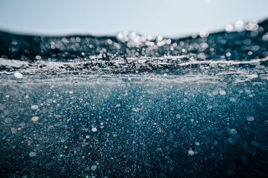 bubbles and foam beneath a rippling sea surface