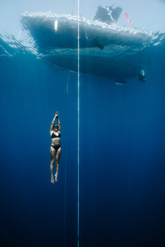 freediver ascending beneath a boat during open-water training