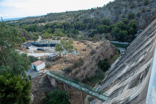 View of a dam with a walkway and valley below