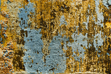 rustic old wall texture with peeling paint in ochre and blue tones © Nacho