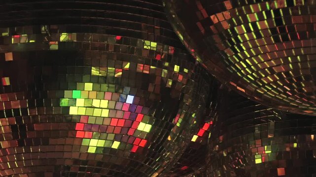 Clustered Mirror Balls Scatter Purple and Blue Light. The mirror ball cluster forms a decorative pattern, with mosaic tiles catching changing colored light across the dark interior.
