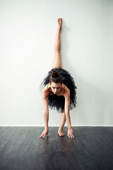 Balance, art and woman in studio for ballet motion, creative ballerina and training. Wall, white background or flexible dancer in routine with elegance, space or talent for exercise, body or dancing