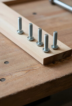 Construction and home improvement, metal bolts inserted into a wooden plank for carpentry project, diy renovation and woodworking craftsmanship