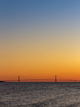 Mackinac Bridge silhouetted at sunset over Lake Huron in Michigan