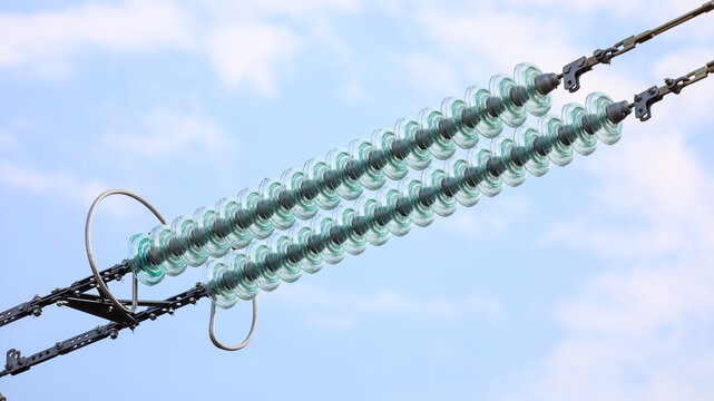 Glass insulators connecting high voltage power lines. Ensuring electrical insulation and supporting the transmission of electric energy across the grid