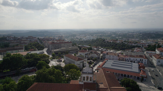Aerial view of the Cathedral of Our Lady of the Conception, featuring historic rooftops, green trees, and urban architecture in Santarem, Santarem, Portugal.