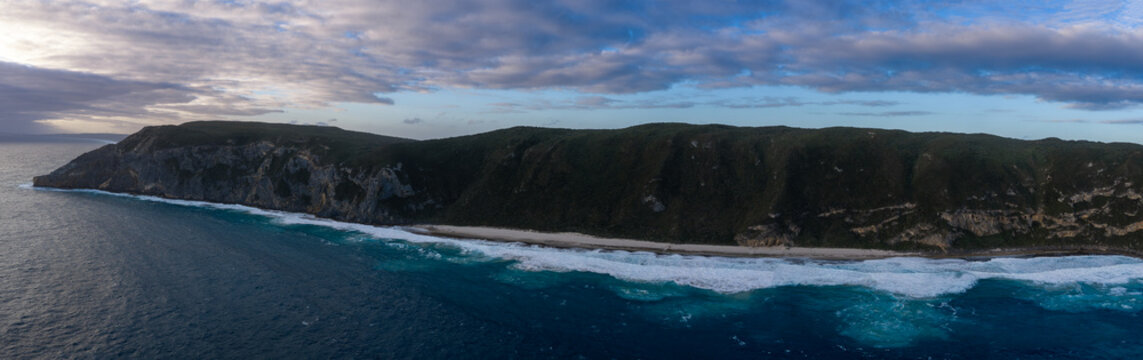 Aerial view of The Gap, a dramatic coastal cliff formation with crashing waves and a sandy beach along the rugged coastline in Torndirrup, Western Australia, Australia.