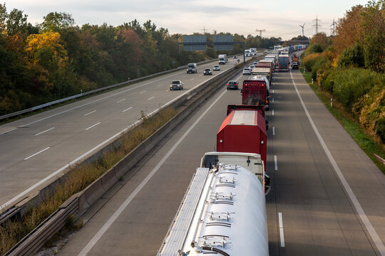 Scenic view queue of trucks european highway traffic jam at sunset sunrise autumn day. Freight congestion accident delays, border disruption transport pressure Europe. Cargo lorry semi-trailers stuck