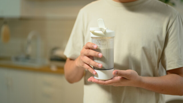 Person Holding Protein Shaker Bottle with Supplement Shake