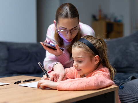 Aunt showing educational content on smartphone to girl