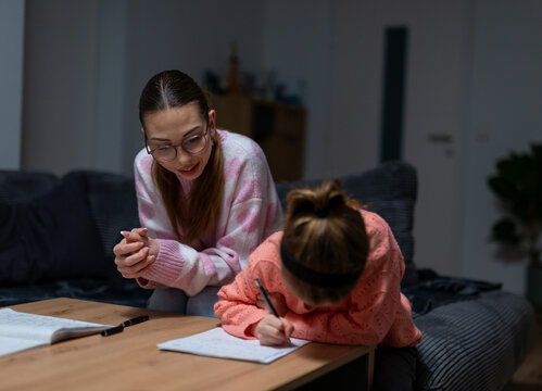 Aunt supervising child while she writes homework