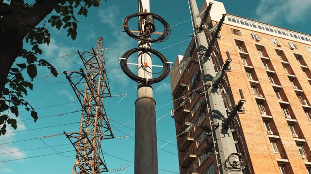 Scenic view of electricity pylons stretching on a street with sky and clouds background.
