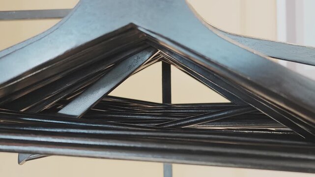Intriguing shot starting from a close up abstract perspective inside a stack of hangers and pulling back to reveal the full objects