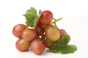 Fototapeta premium Bunch of fresh ripe grapes with green leaves on white background