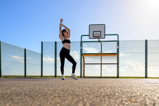 Woman Stretching Basketball on Outdoor Court