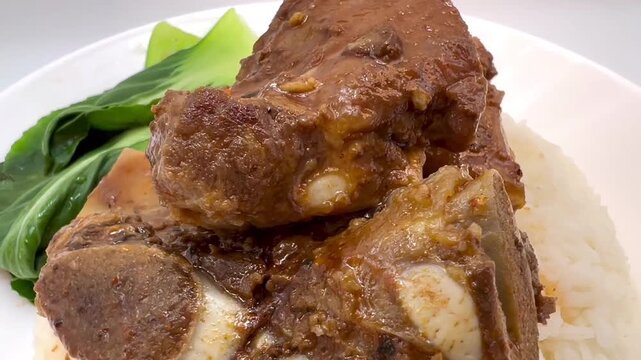  Horizontal Close-Up of Bone-In Meat in Brown Sauce with Rice and Bok Choy