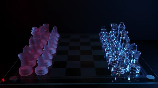 Close-up camera pulling back and rising above frosted and clear glass chess pieces howcasing strategy, leadership, and decision-making