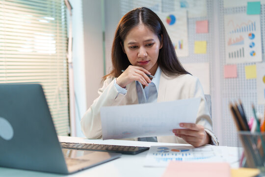 Businesswoman Analyzing Financial Documents and Investment Charts