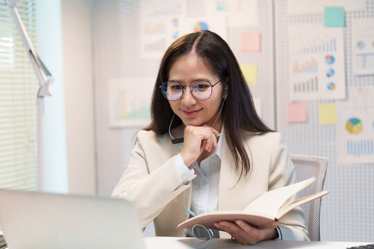 Businesswoman Participating in Online Video Conference with Notebook
