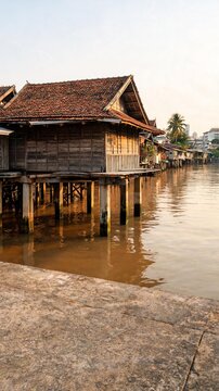 Traditional stilt house above high canal water concept