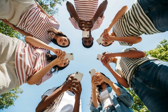 Diverse group of friends enjoying a sunny day together looking upwards with joyful expressions