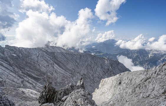 Mountaineer on rocky peak, descent to Ofentalscharte, behind rock face of Ofentalschneid, mountain tour to the summit of Hochkalter, Hochkalter crossing, Berchtesgaden Alps, Bavaria, Germany