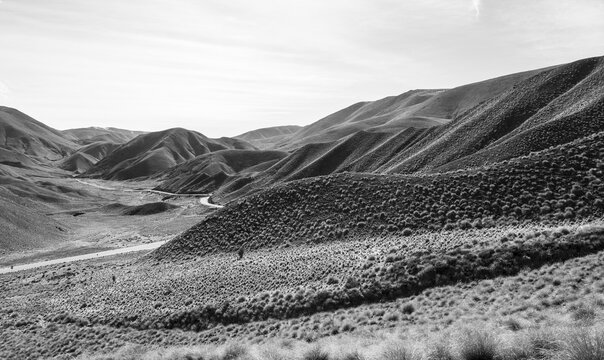 Black and white photo, barren mountain landscape with pass road, Lindis Pass, Southern Alps, Otago, South Island, New Zealand