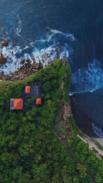 Ocean rocky coastline with cliffs and waves in Bali. Top down drone view