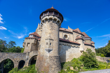 Historic castle in Austria surrounded by picturesque countryside and lush alpine scenery, presenting a timeless European architectural landmark beneath a dramatic sky. The elegant fortress © Yuliia