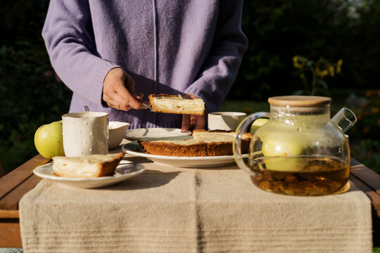 Serving homemade apple pie with tea at garden table
