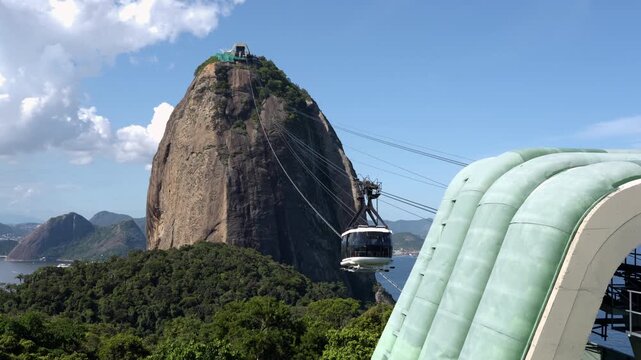 Cable car ascending from Morro da Urca to Sugarloaf Mountain on a sunny day, Rio de Janeiro, Brazil.