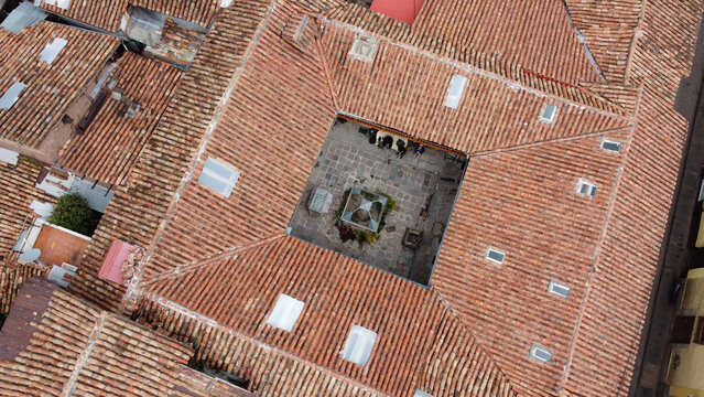 Aerial view of a traditional courtyard with terracotta tiled roofs and stone flooring in the historic center of Cusco, Cusco, Peru.
