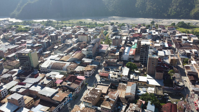 Aerial view of the dense urban landscape with residential rooftops and a river in the background in La Merced, Junin, Peru.