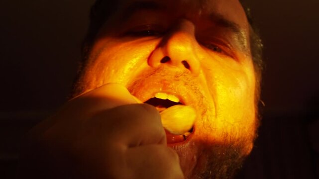 a man greedily eats snacks