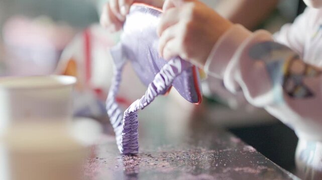 Child's hands sprinkling glitter for arts and crafts