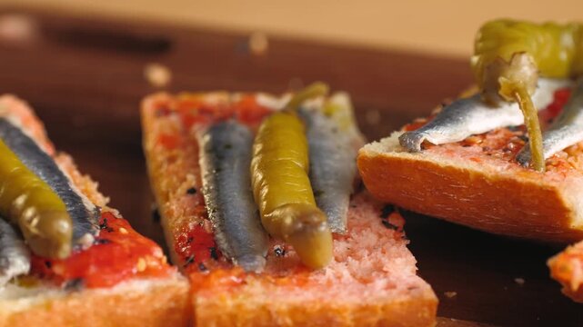 Pan con tomate with anchovies and guindilla pepper, close up of classic Spanish tapas gilda with marinated boquerones on tomato bread, Spanish cuisine bar snack