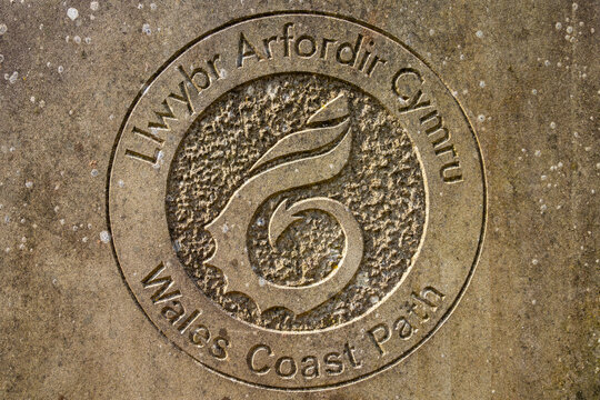 Wales Coast Path logo engraved on a stone surface in Chepstow Wales